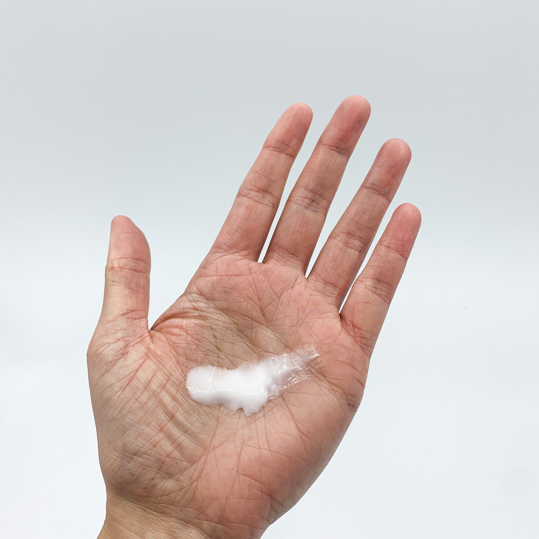Lightweight and fast absorbing ho wood, grapefruit, and lavender lotion smeared on hands